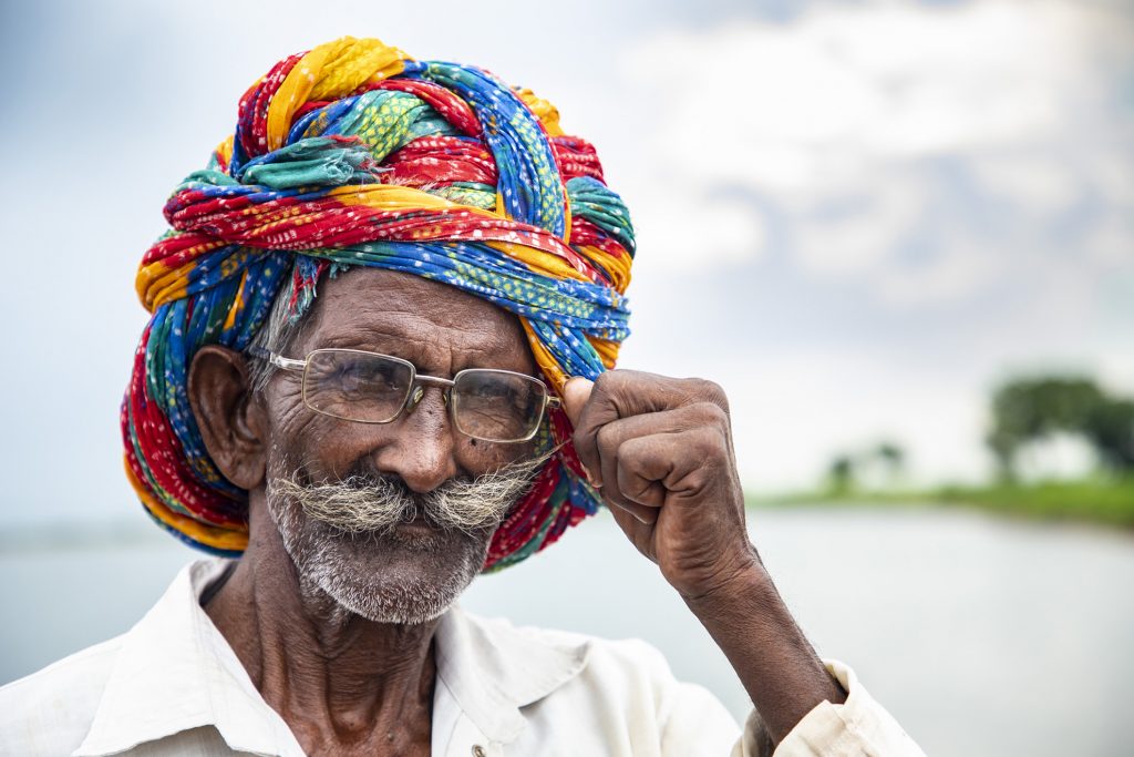 Old man with long mustaches and colorful turban on his head. This happy old man fron Kota, Rajasthan, India